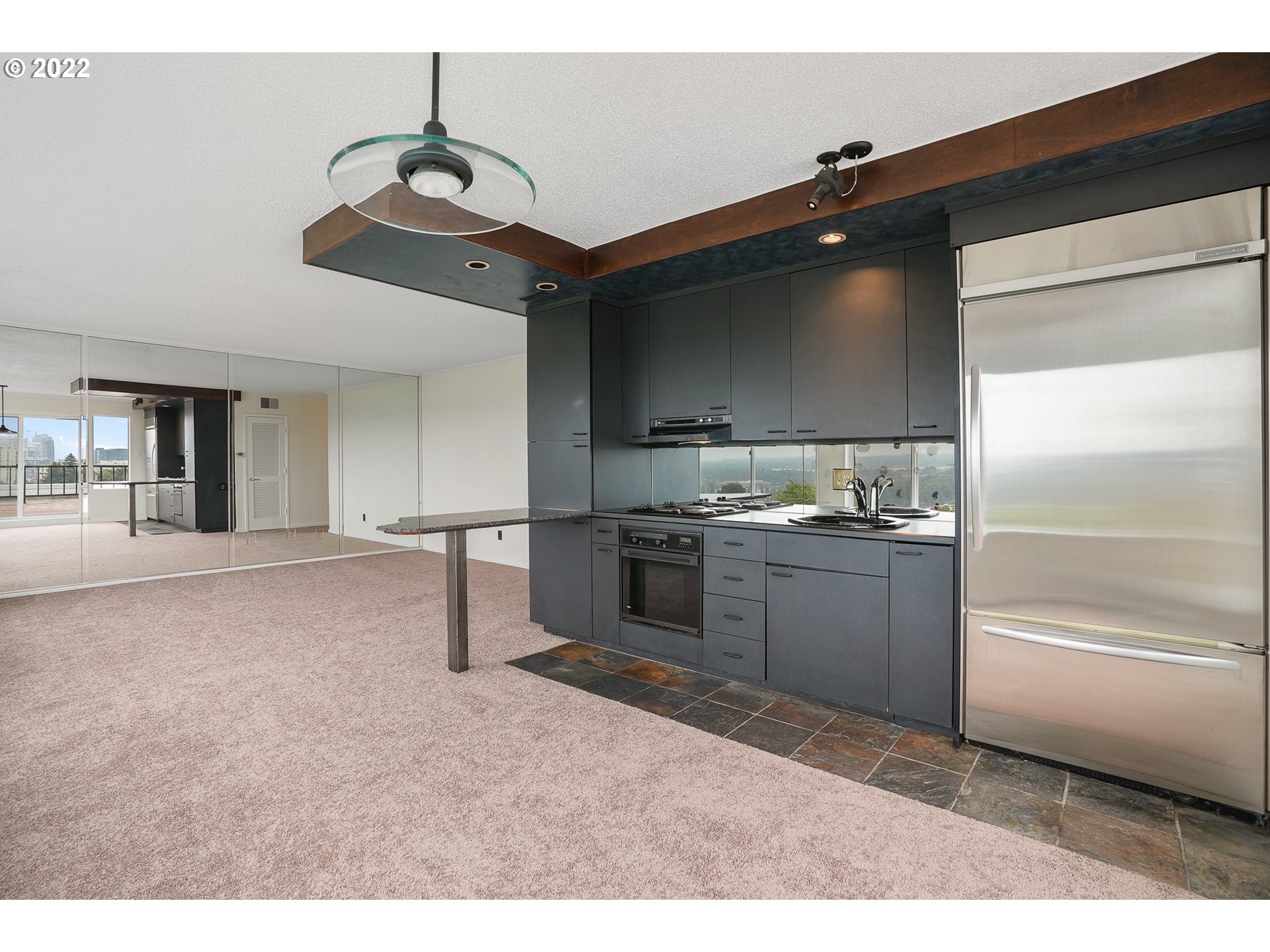 3701 Southwest Condor Avenue, Unit T3 Portland, OR 97239 - Photo 7 of 23 a kitchen with stainless steel appliances granite countertop a sink and cabinets