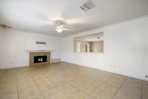 an empty room with fan and fireplace
