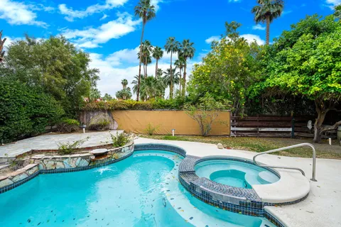 a small pool with lawn chairs and a fire pit