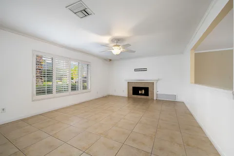 a view of an empty room with a fireplace and a window