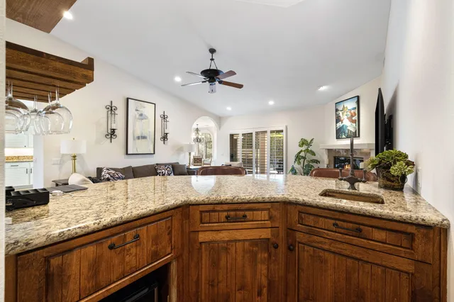 a kitchen with granite countertop a sink stove and cabinets