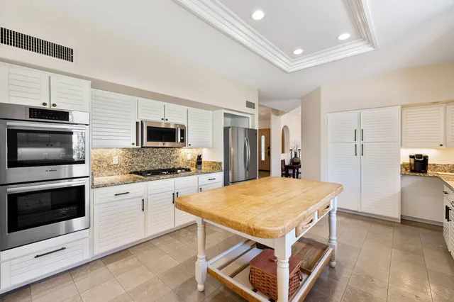 a bathroom with a granite countertop sink and a large mirror