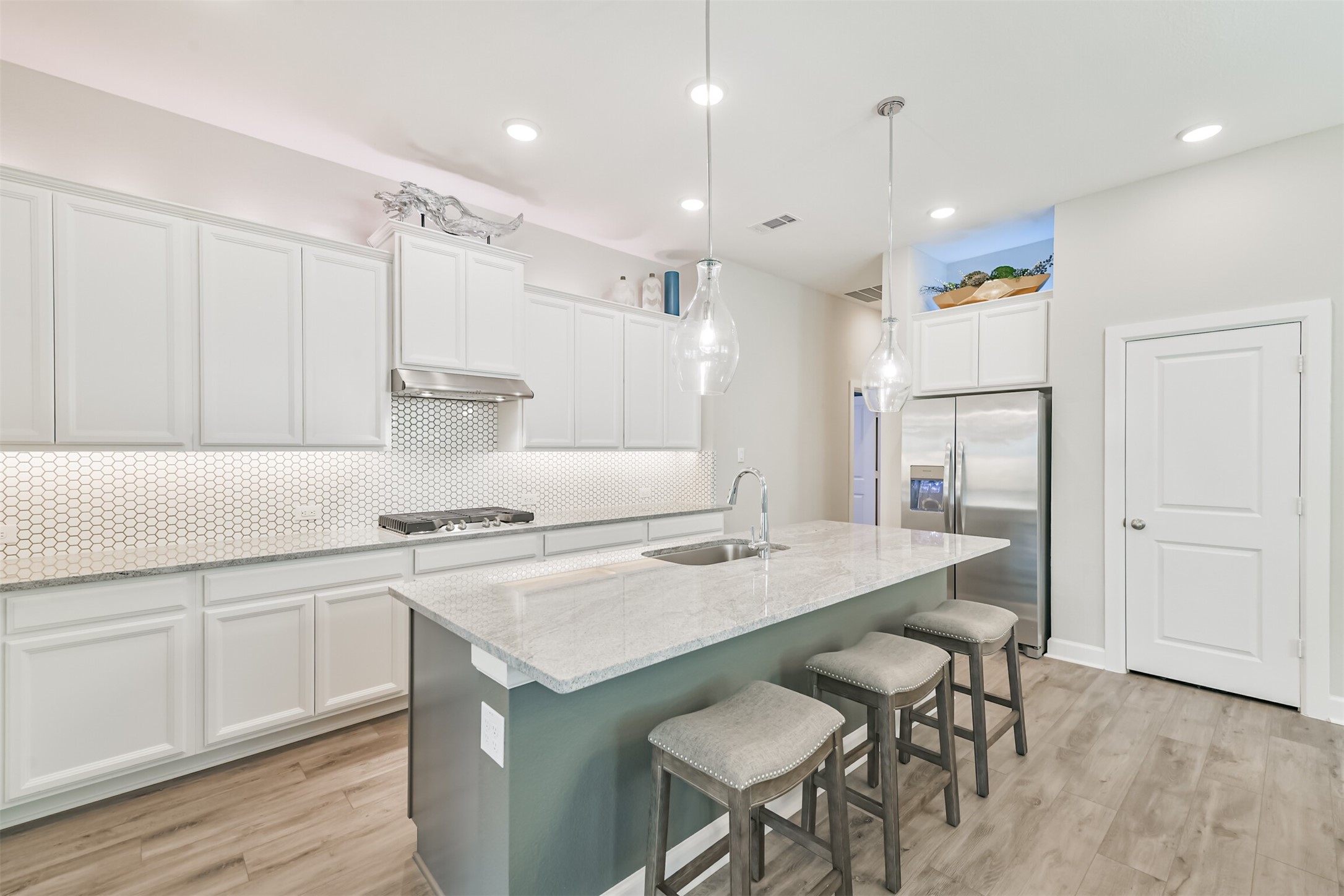 15611 Rising Wren Court Conroe, TX 77302 - Photo 9 of 38 a kitchen with a dining table chairs refrigerator and cabinets