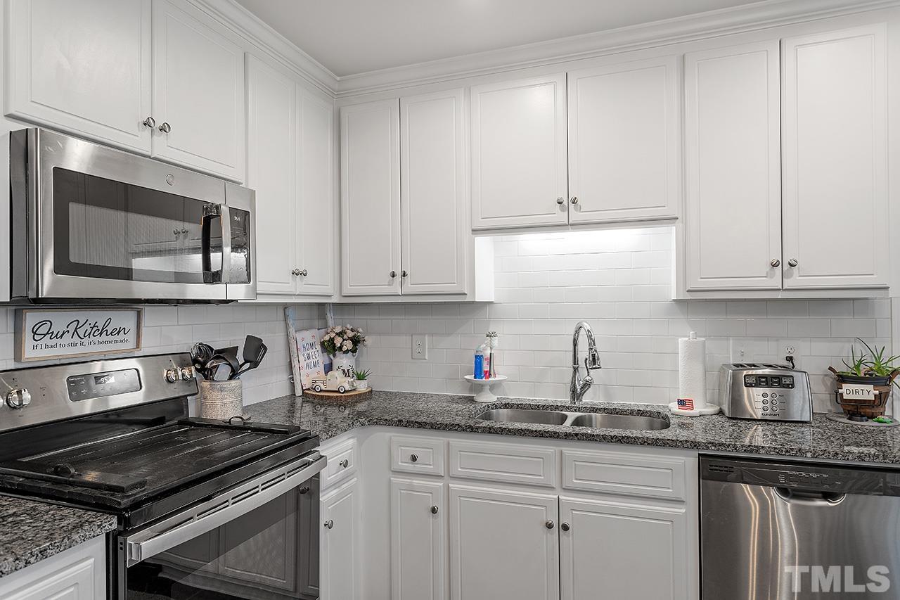 3518 Friday Road Sims, NC 27880 - Photo 19 of 28 a kitchen with granite countertop white cabinets and a stove a sink