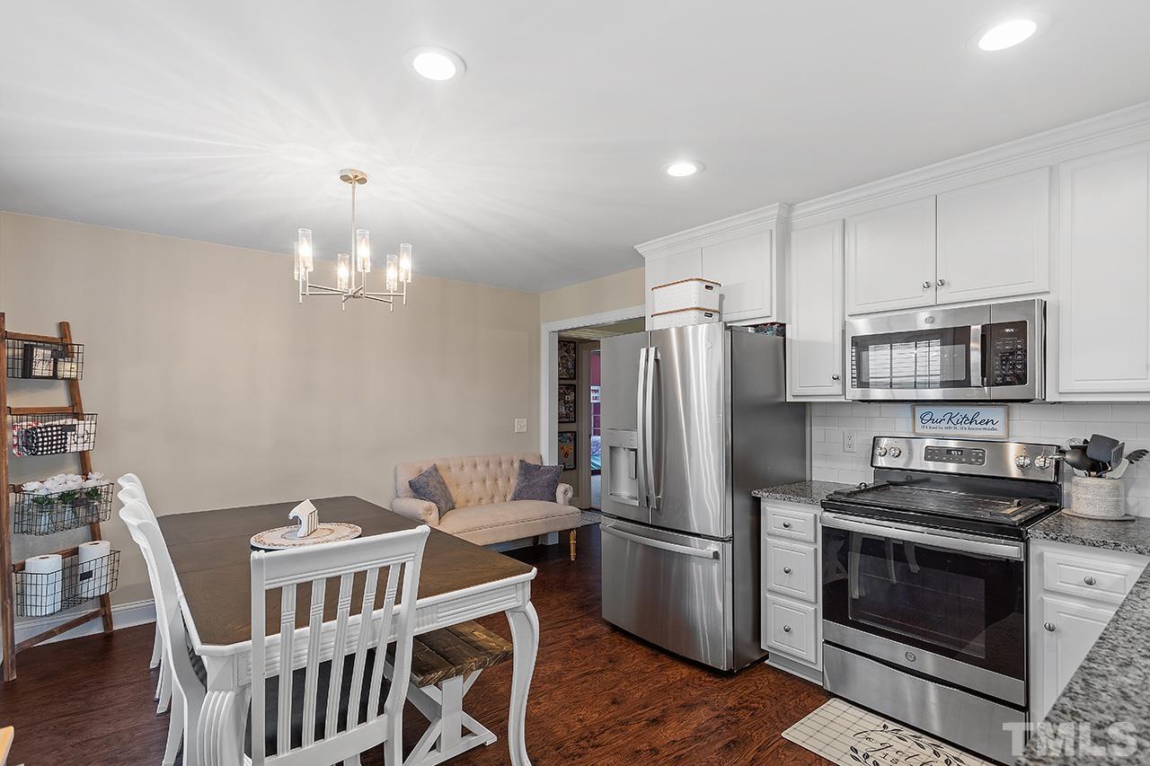 3518 Friday Road Sims, NC 27880 - Photo 20 of 28 a kitchen with stainless steel appliances a refrigerator a stove a sink and a dining table with chairs