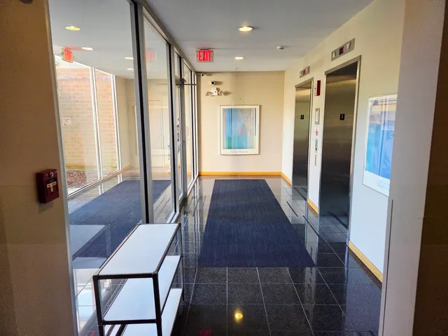 a view of a hallway with furniture and a window