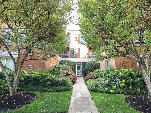 a front view of a house with a yard and fountain in middle