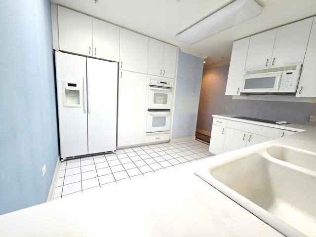 a kitchen with a sink a refrigerator and cabinets