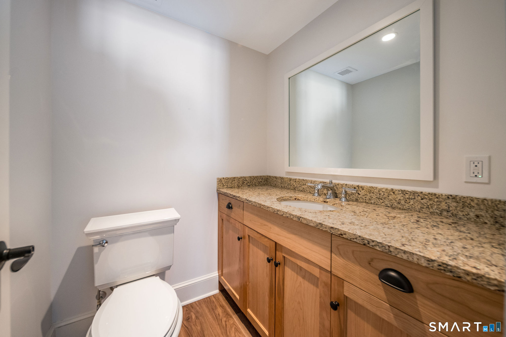81 Strawberry Hill Road Madison, CT 06443 - Photo 23 of 40 a bathroom with a granite countertop toilet sink and mirror