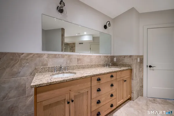 a bathroom with a granite countertop sink a toilet and bathtub