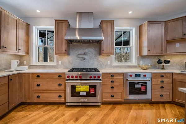 a kitchen with stainless steel appliances kitchen island granite countertop a table and chairs in it