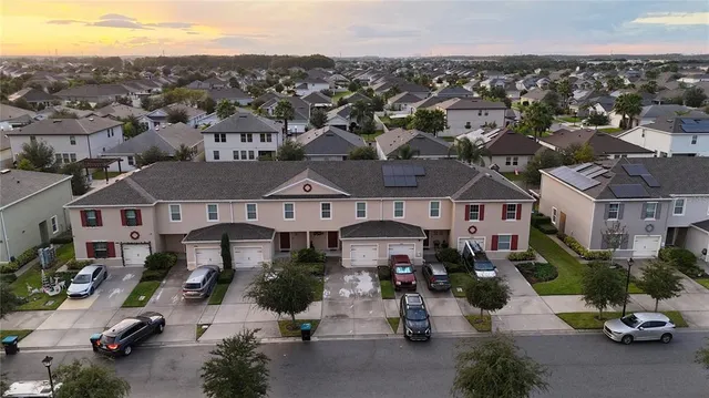 an aerial view of multiple houses with a city street
