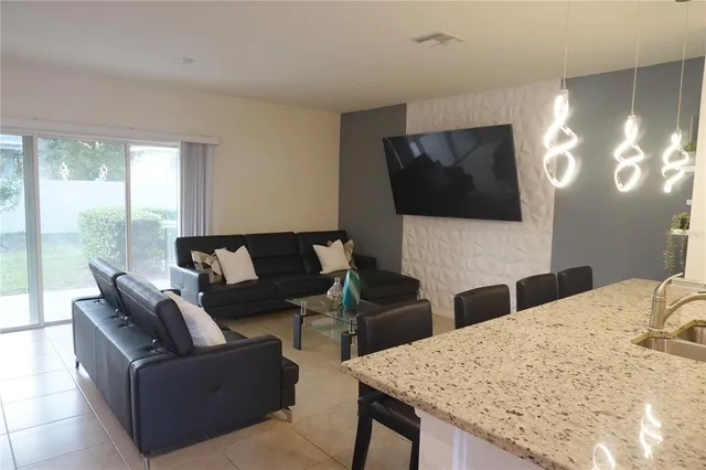 a living room with furniture a large window and a flat screen tv