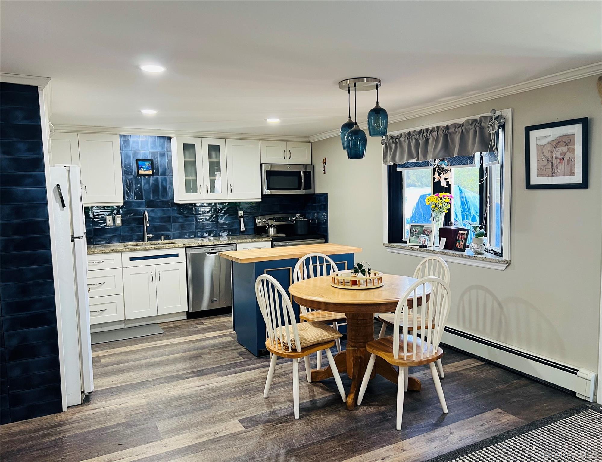 38 Riviera Drive Selden, NY 11784 - Photo 2 of 12 Kitchen featuring white cabinetry, glass insert cabinets, appliances with stainless steel finishes, tasteful backsplash, and granite counters