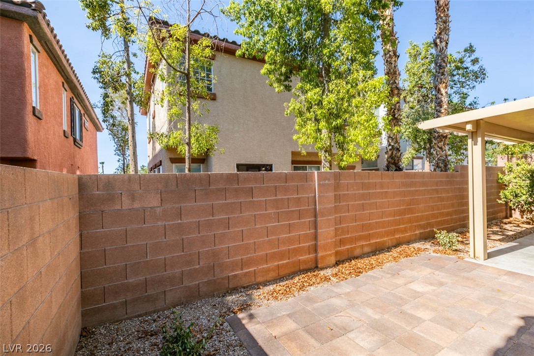 8937 Caledon Ridge Court Las Vegas, NV 89149 - Photo 40 of 43 A spacious backyard patio, framed by a sturdy block fence, offers private outdoor living.