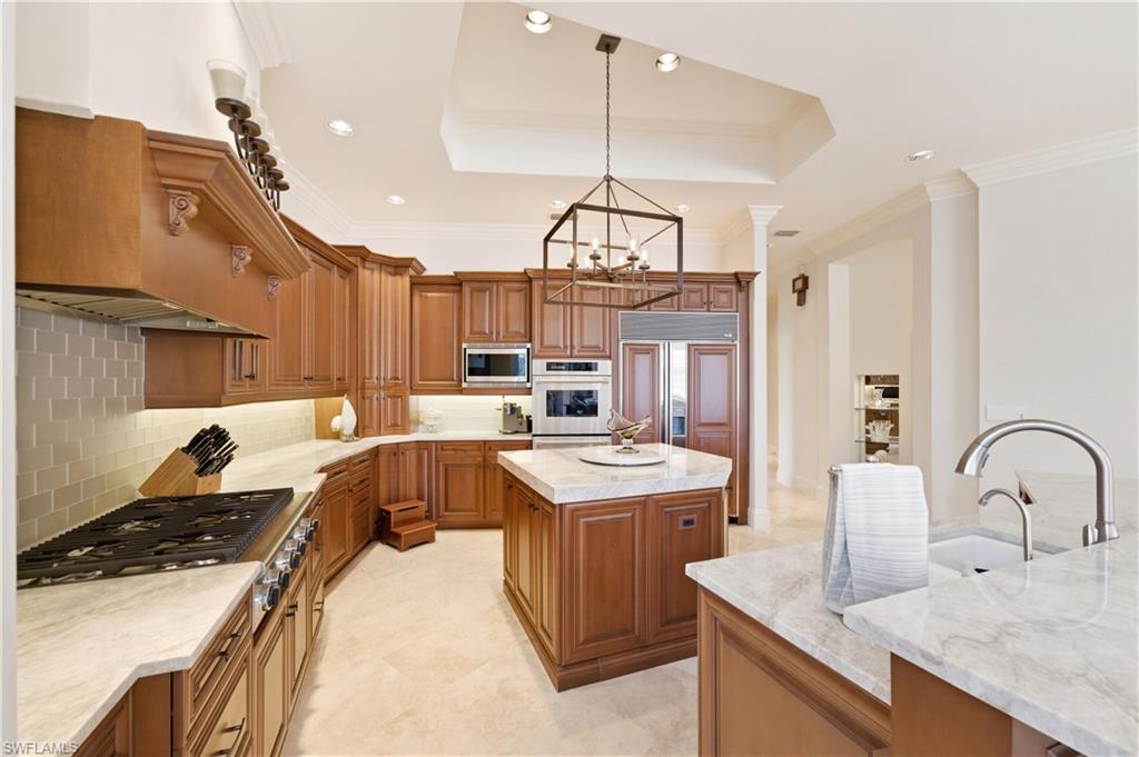 361 Pirates Bight Naples, FL 34103 - Photo 12 of 45 a kitchen with a sink a stove and chairs
