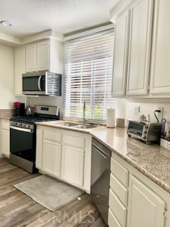 123 Pasto Rico Rancho Santa Margarita, CA 92688 - Photo 5 of 13 a kitchen with granite countertop a sink stainless steel appliances and cabinets