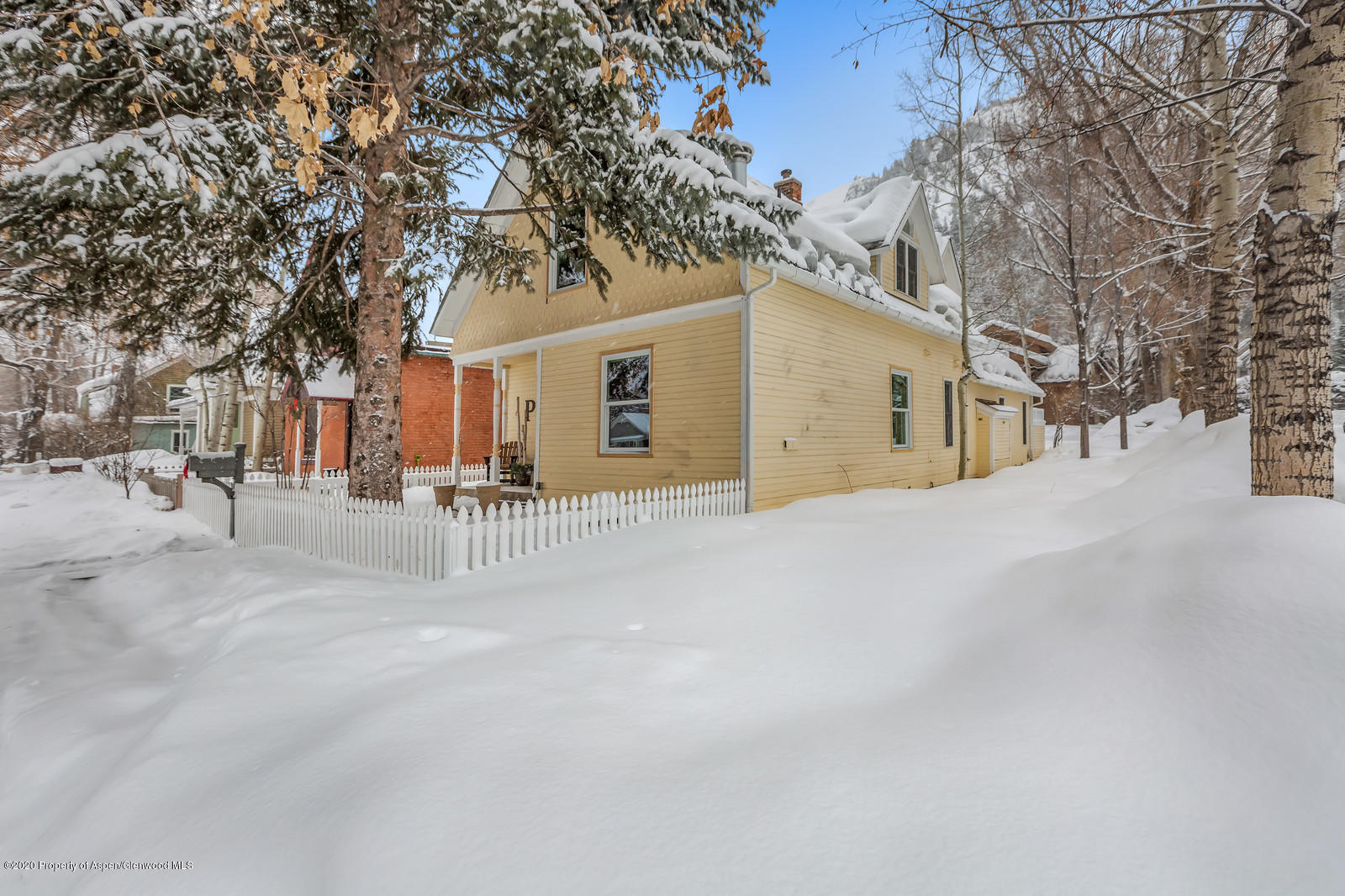 633 West Main Street Aspen, CO 81611 - Photo 21 of 46 a view of a white house with a large tree