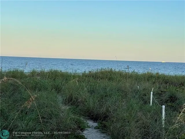 a view of a lush green outdoor space with a lake view and mountain view