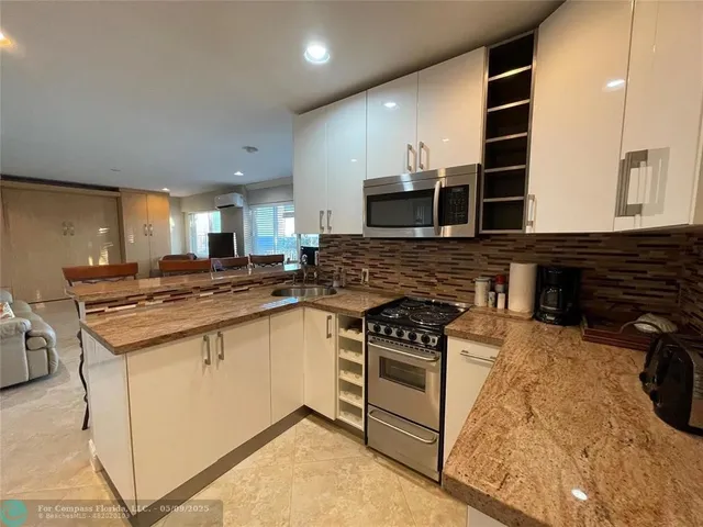 a kitchen with stainless steel appliances granite countertop a stove and a sink
