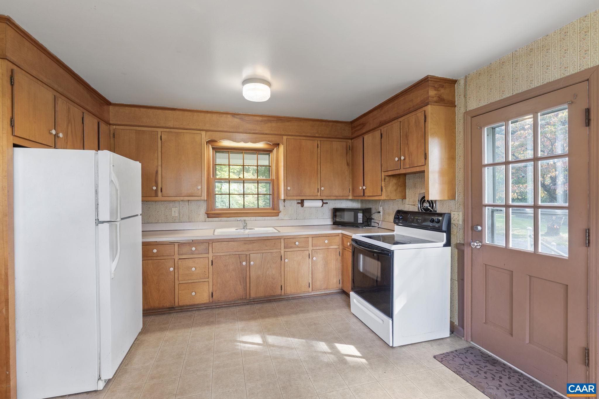 9281 Dick Woods Road Afton, VA 22920 - Photo 12 of 29 a kitchen with stainless steel appliances granite countertop a refrigerator a sink a stove and white cabinets