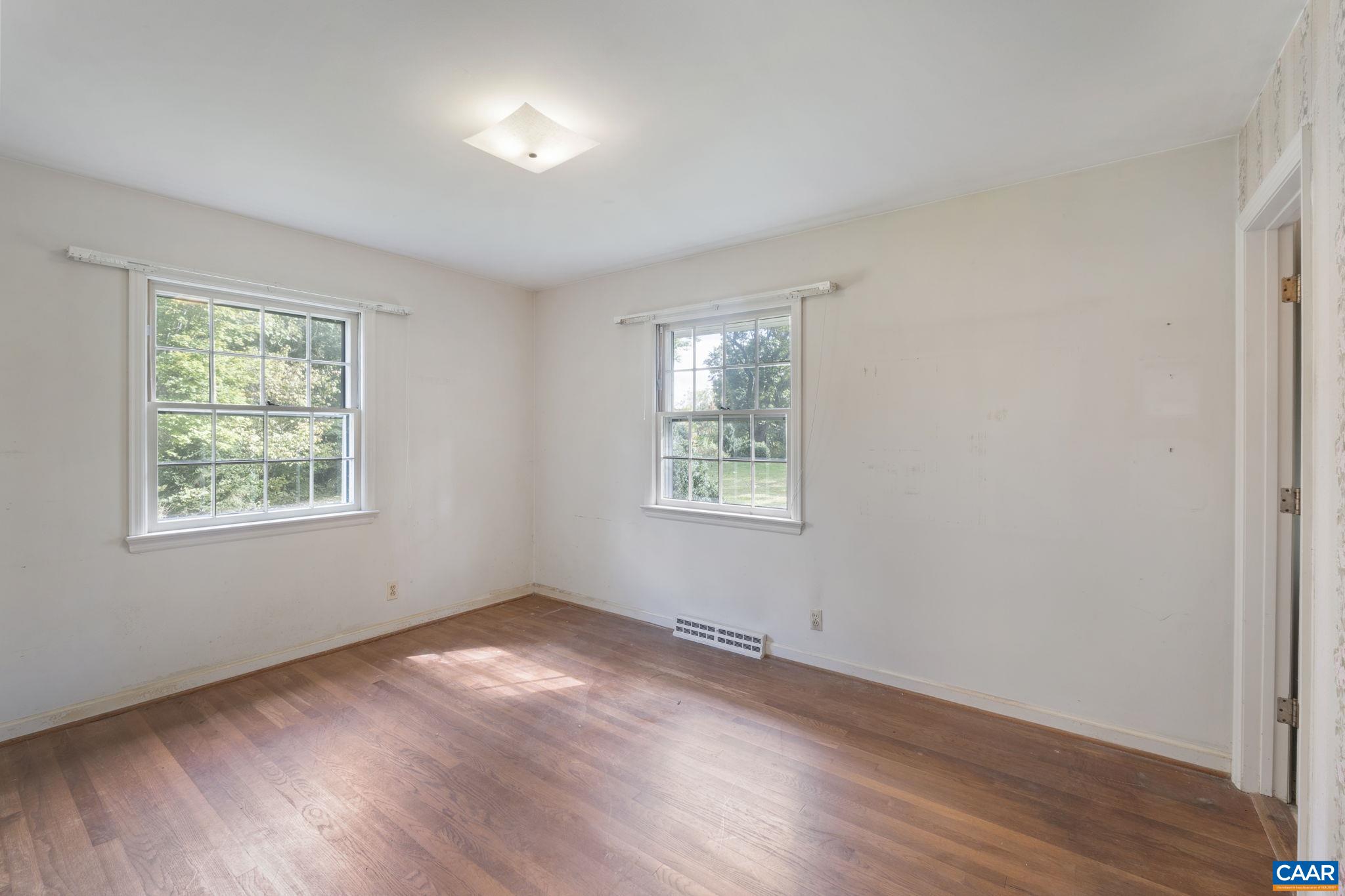 9281 Dick Woods Road Afton, VA 22920 - Photo 17 of 29 an empty room with wooden floor and windows