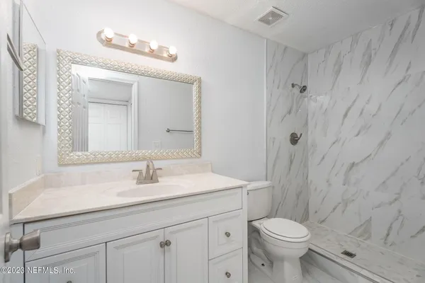 a bathroom with a sink a toilet and shower