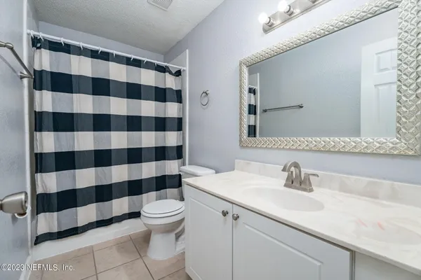 a bathroom with a sink a toilet a mirror and shower