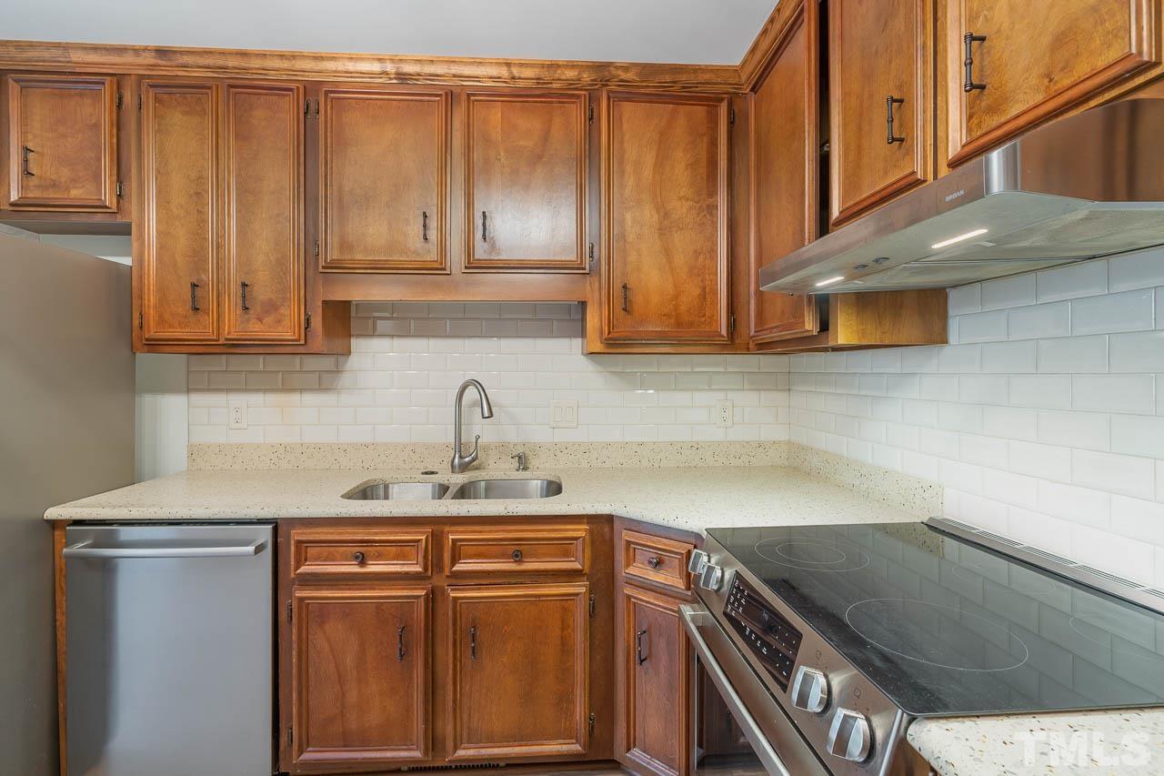 2913 Rue Sans Famille Raleigh, NC 27607 - Photo 12 of 25 a kitchen with stainless steel appliances granite countertop a sink and cabinets