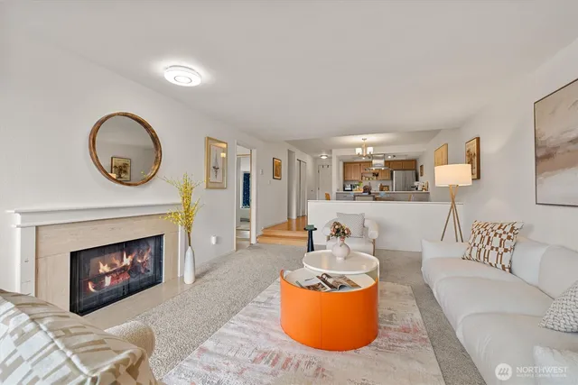 a living room with furniture a fireplace and a floor to ceiling window