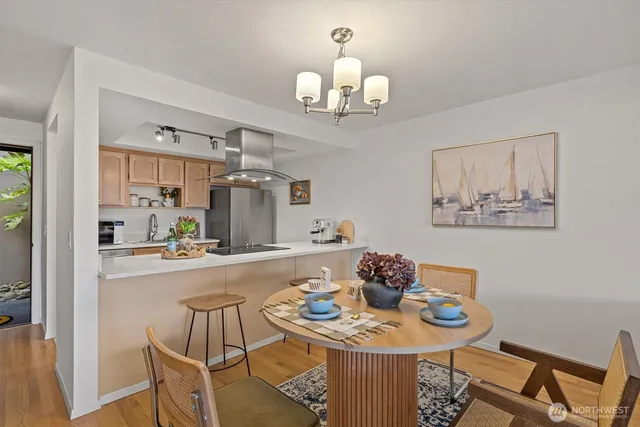 a kitchen with a chandelier a refrigerator and cabinets