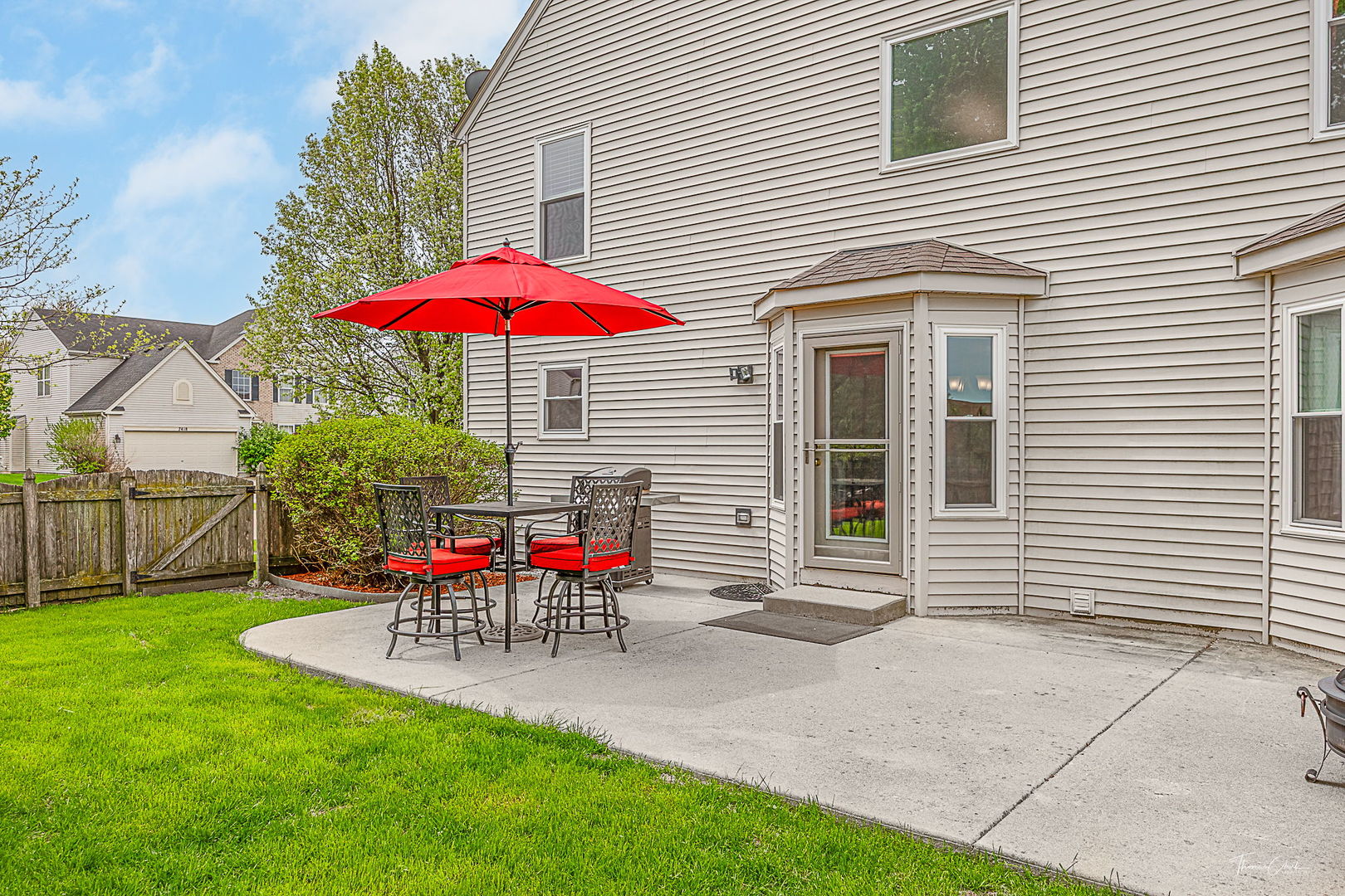 2031 Crosswind Drive Plainfield, IL 60586 - Photo 33 of 35 a view of a patio with a table and chairs under an umbrella