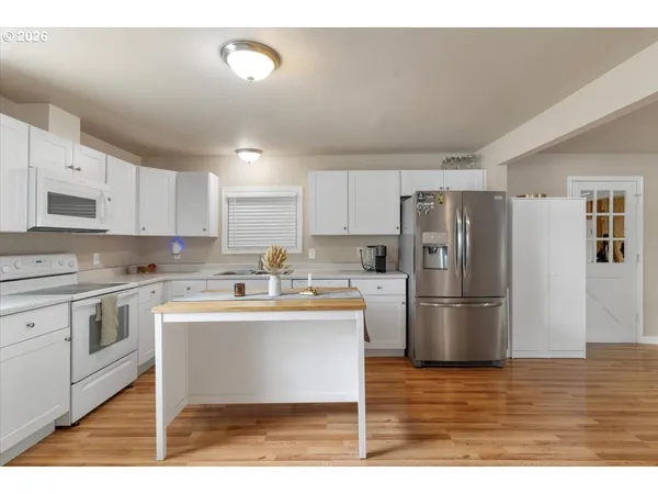 a kitchen with a sink a refrigerator and white cabinets