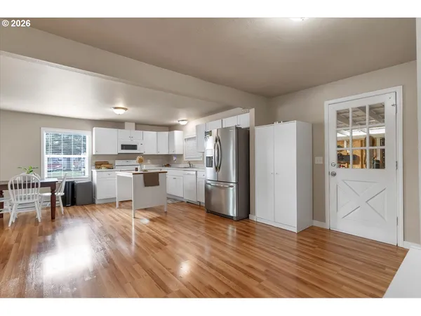 a kitchen with stainless steel appliances wooden floor and a refrigerator