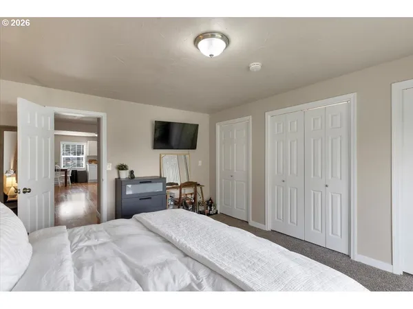 a bedroom with a bed and a flat tv screen on dresser