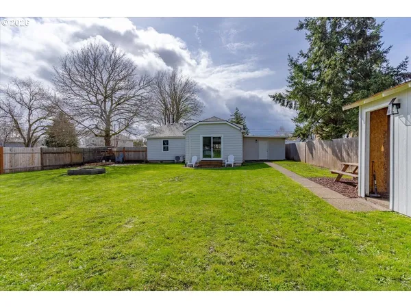 a view of a house with a big yard and large tree