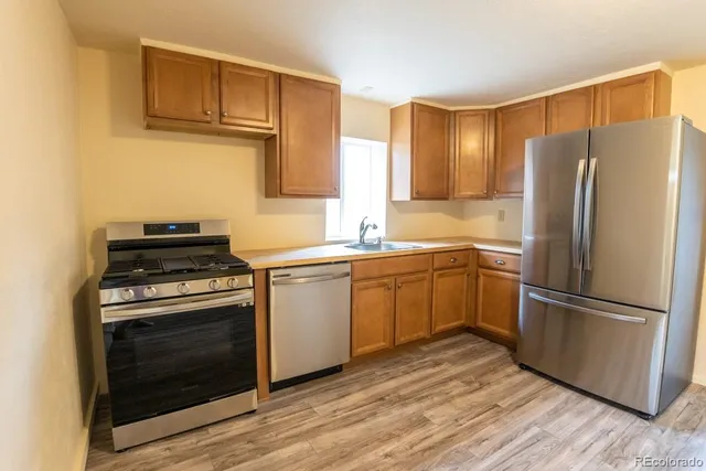 a kitchen with a refrigerator stove and wooden cabinets