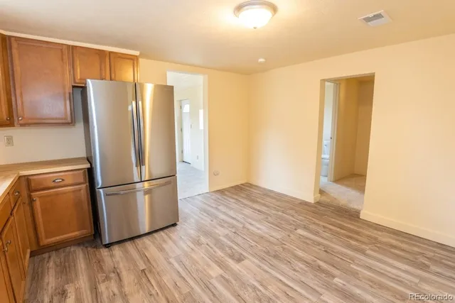 a view of a kitchen with wooden floor and a refrigerator
