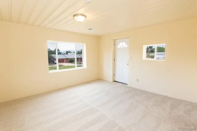 an empty room with windows and closet