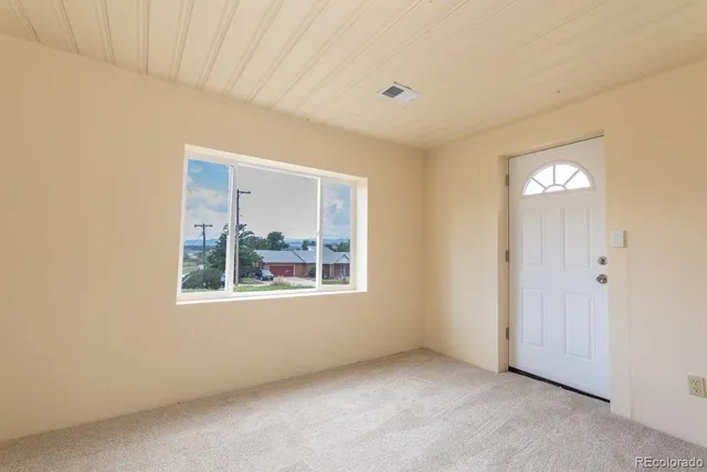 an empty room with windows and closet