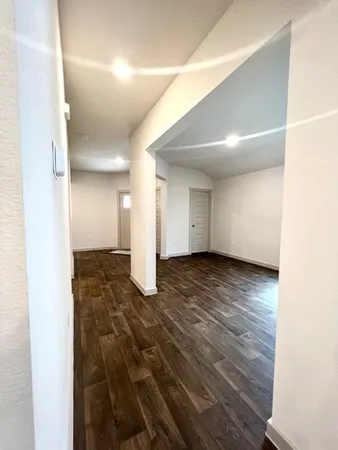 a view of empty room with wooden floor