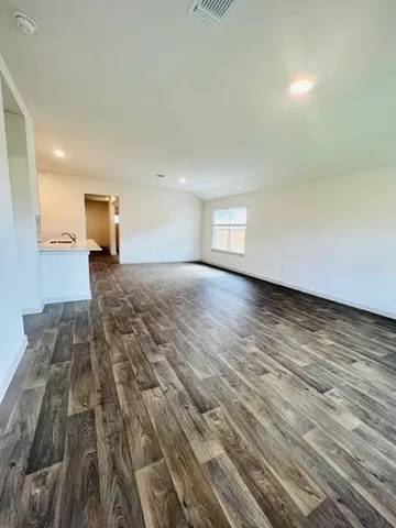 a view of a livingroom with wooden floor and a cabinet