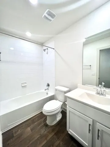 a bathroom with a sink a toilet a mirror and bathtub