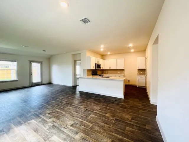 a view of kitchen and kitchen with granite countertop sink