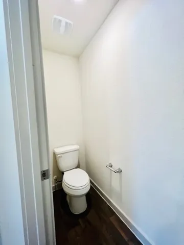 a white toilet sitting next to a shower