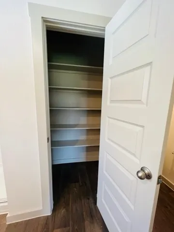 a view of walk in closet with empty racks