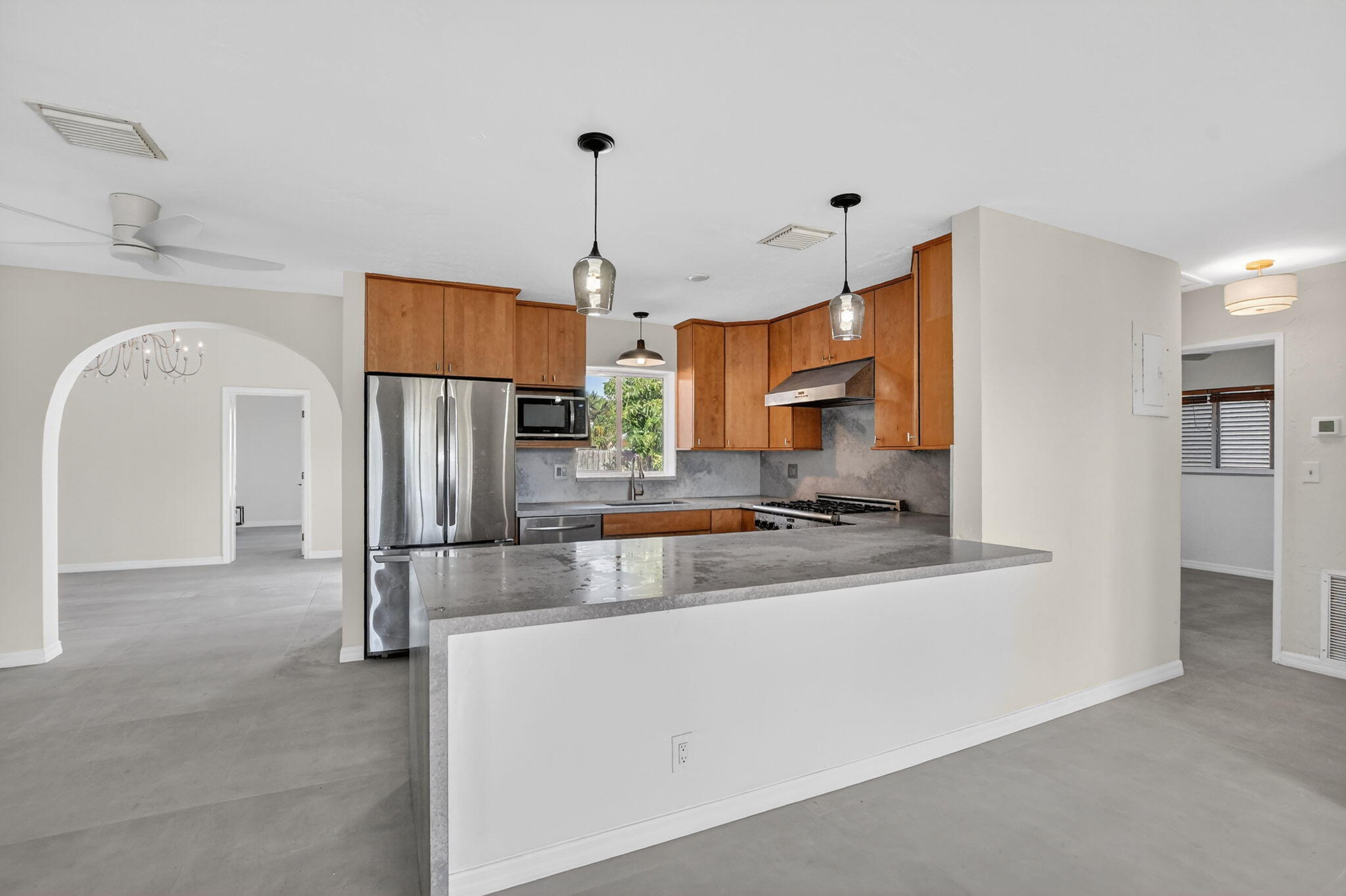 a kitchen with stainless steel appliances granite countertop a refrigerator a sink a stove and a cabinets