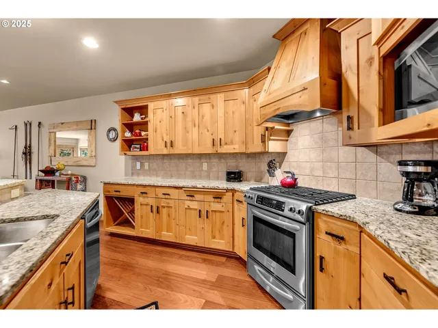 a kitchen with stainless steel appliances granite countertop a stove a sink and a microwave