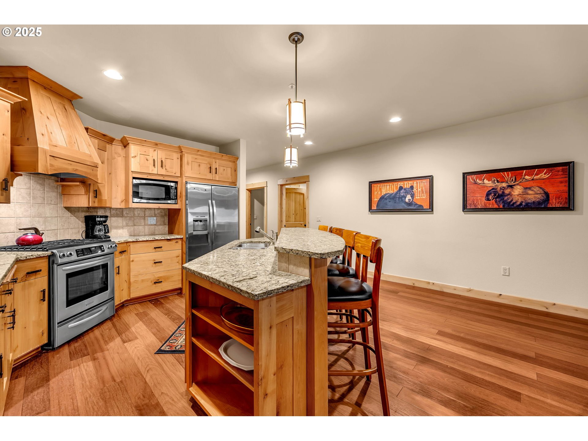 31254 East Collins Lake Road, Unit 22 Government Camp, OR 97028 - Photo 15 of 44 a kitchen with stainless steel appliances granite countertop a kitchen island hardwood floor sink stove dining table and chairs