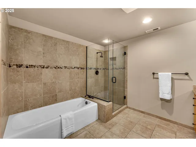 a bathroom with a tub a shower and a sink